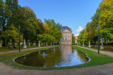 Trier, Almanya - 11 Ekim 2024: Trier, Rhineland-Palatinate, Almanya 'da yerel halk ve ziyaretçilerle birlikte Seçim Sarayı ve bahçesinin manzarası