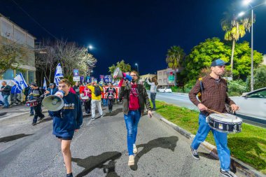 Hayfa, İsrail - 14 Aralık 2024: Hükümete karşı bir protesto yürüyüşü sahnesi, yeni seçimler ve insanların yer aldığı bir rehine anlaşması, çeşitli tabelalar ve bayraklar. Hayfa, İsrail
