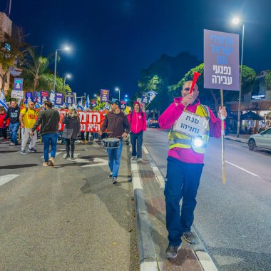 Hayfa, İsrail - 14 Aralık 2024: Hükümete karşı bir protesto yürüyüşü sahnesi, yeni seçimler ve insanların yer aldığı bir rehine anlaşması, çeşitli tabelalar ve bayraklar. Hayfa, İsrail
