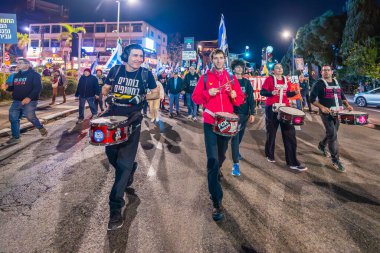 Hayfa, İsrail - 14 Aralık 2024: Hükümete karşı bir protesto yürüyüşü sahnesi, yeni seçimler ve insanların yer aldığı bir rehine anlaşması, çeşitli tabelalar ve bayraklar. Hayfa, İsrail