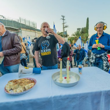 Kishon, Israel - December 20, 2024: Activist perform ceremonial Kabalat Shabat, near the Kishon detention center in support of activist arrested after firing Naval Flares. Kishon, Israel clipart