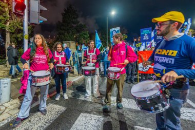 Hayfa, İsrail - 21 Aralık 2024: İnsanlar çeşitli işaret ve bayraklarla bir protesto yürüyüşüne katılarak yeni seçimler ve rehine anlaşması çağrısında bulundu. Hayfa, İsrail