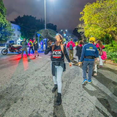 Hayfa, İsrail - 21 Aralık 2024: İnsanlar çeşitli tabelalar ve bayraklarla birlikte protesto yürüyüşüne katılarak yeni seçimler ve rehine anlaşması çağrısında bulundular. Hayfa, İsrail