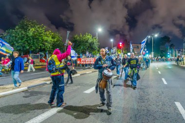 Hayfa, İsrail - 21 Aralık 2024: İnsanlar çeşitli tabelalar ve bayraklarla birlikte protesto yürüyüşüne katılarak yeni seçimler ve rehine anlaşması çağrısında bulundular. Hayfa, İsrail