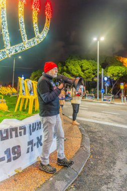 Hayfa, İsrail - 29 Aralık 2024: Tabela ve bayraklı insanların günlük protesto gösterilerinde, İsrail 'in Hayfa kentinde rehine anlaşması çağrısında bulunması