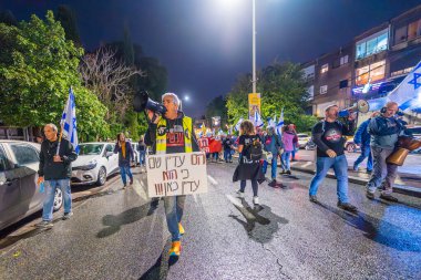 Hayfa, İsrail - 28 Aralık 2024: Çeşitli tabela ve bayraklara sahip insanlar yeni seçim ve rehine anlaşması çağrısında bulunan bir protesto mitingine katıldılar. Hayfa, İsrail