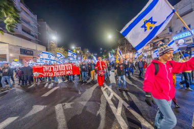 Hayfa, İsrail - 28 Aralık 2024: Çeşitli tabela ve bayraklara sahip insanlar yeni seçim ve rehine anlaşması çağrısında bulunan bir protesto mitingine katıldılar. Hayfa, İsrail