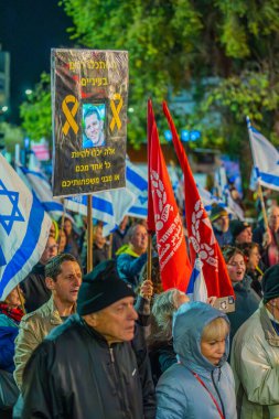 Hayfa, İsrail - 28 Aralık 2024: Çeşitli tabela ve bayraklara sahip bir kalabalık, yeni seçim ve rehine anlaşması çağrısında bulunan bir protesto mitingine katıldı. Hayfa, İsrail