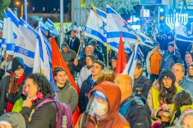 Hayfa, İsrail - 28 Aralık 2024: Çeşitli tabela ve bayraklara sahip bir kalabalık, yeni seçim ve rehine anlaşması çağrısında bulunan bir protesto mitingine katıldı. Hayfa, İsrail
