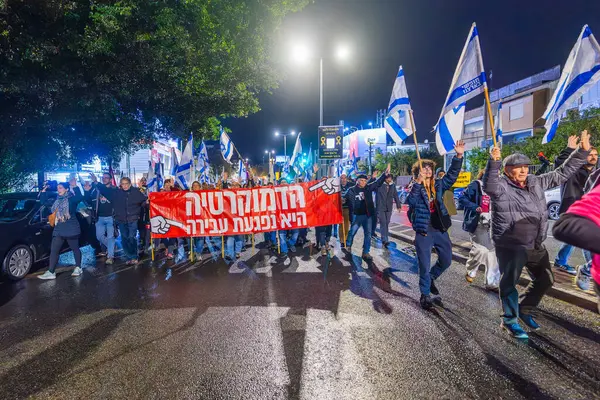 Hayfa, İsrail - 28 Aralık 2024: Çeşitli tabela ve bayraklara sahip insanlar yeni seçim ve rehine anlaşması çağrısında bulunan bir protesto mitingine katıldılar. Hayfa, İsrail