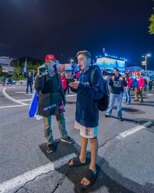 Hayfa, İsrail - 4 Ocak 2025: Çeşitli tabelaları ve bayrakları olan insanlar yeni seçim ve rehine anlaşması çağrısında bulunan bir protesto mitingine katıldılar. Hayfa, İsrail