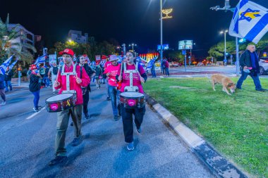 Hayfa, İsrail - 4 Ocak 2025: İnsanlar çeşitli tabelalar ve bayraklarla bir protesto yürüyüşüne katılarak yeni seçimler ve rehine anlaşması çağrısında bulundular. Hayfa, İsrail