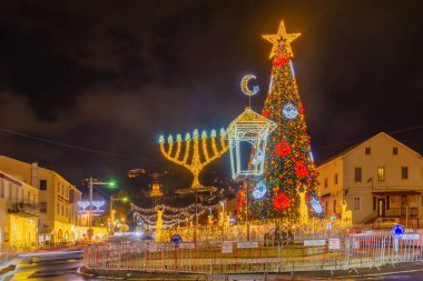 Hayfa, İsrail - 30 Aralık 2024: Alman Kolonisinde Tatil Tatili, bir Noel ağacı, Hanuka Menorah, Müslüman Hilal ve arka planda İsrail 'in Hayfa kentindeki Bahai türbesi