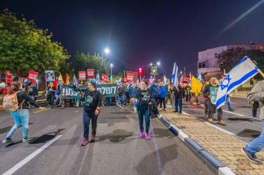 Hayfa, İsrail - 11 Ocak 2025: Çeşitli tabelaları ve bayrakları olan insanlar, savaşın sona ermesi, rehine anlaşması ve yeni seçimler için düzenlenen protesto mitingine katıldılar. Hayfa, İsrail