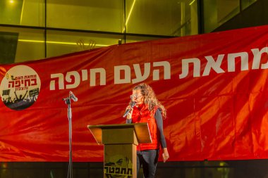 Hayfa, İsrail - 11 Ocak 2025: Eylemci Michal Sela kalabalığa hitaben yaptığı konuşmada, savaşın sona ermesi, rehine anlaşması ve yeni seçimler çağrısında bulundu. Hayfa, İsrail