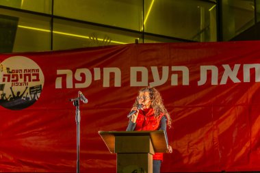 Hayfa, İsrail - 11 Ocak 2025: Eylemci Michal Sela kalabalığa hitaben yaptığı konuşmada, savaşın sona ermesi, rehine anlaşması ve yeni seçimler çağrısında bulundu. Hayfa, İsrail