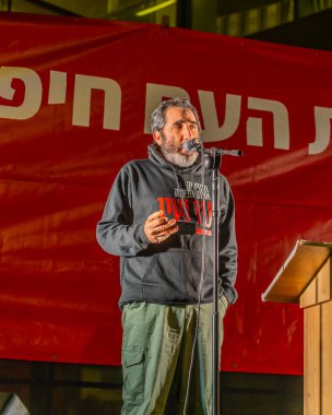 Hayfa, İsrail - 11 Ocak 2025: 85 yaşındaki babası kaçırılan ve öldürülen Boaz Zalmanovich, İsrail 'in Hayfa kentinde düzenlenen bir protesto mitinginde kalabalığa konuştu.