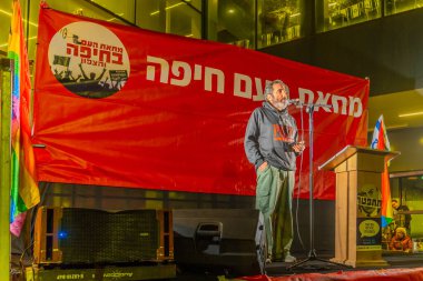 Haifa, Israel - January 11, 2025: Boaz Zalmanovich, whos 85 years old father was kidnapped and murderred, speaks to the crowd, part of a protest rally in Haifa, Israel clipart