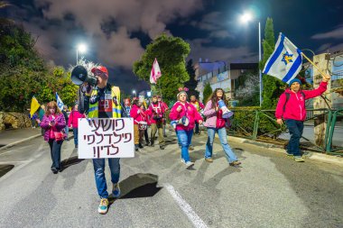 Hayfa, İsrail - 08 Şubat 2025: İnsanlar savaşın sona ermesi, rehine anlaşmasının tamamlanması ve yeni seçimler çağrısında bulunan bir protesto yürüyüşüne katılıyor. Hayfa, İsrail