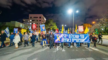 Hayfa, İsrail - 08 Şubat 2025: Çeşitli tabela ve bayraklara sahip insanlar savaşın sona ermesi, rehine anlaşmasının tamamlanması ve yeni seçimler için düzenlenen protesto mitingine katıldılar. Hayfa, İsrail