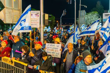 Hayfa, İsrail - 08 Şubat 2025: Çeşitli tabela ve bayraklara sahip bir grup insan, savaşın sona ermesi, rehine anlaşmasının tamamlanması ve yeni seçimler için düzenlenen protesto mitingine katıldı. Hayfa, İsrail