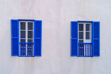 Eski bir evin duvarındaki mavi pencere ve panjurların görüntüsü. Essaouira (Mogador), Fas