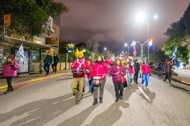 Hayfa, İsrail - 22 Şubat 2025: İnsanlar savaşın sona ermesi, rehine anlaşmasının tamamlanması ve yeni seçimler çağrısında bulunan bir protesto yürüyüşüne katılıyor. Hayfa, İsrail