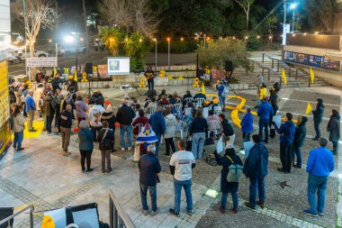 Hayfa, İsrail - 27 Şubat 2025: Rehine posterleri ve diğer işaretlerle dolu kalabalık, rehineler Hayfa, İsrail 'in destek toplantısına katıldı