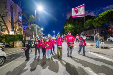 Hayfa, İsrail - 01 Mart 2025: İnsanlar savaşın sona ermesi, rehine anlaşmasının tamamlanması ve yeni seçimler çağrısında bulunan bir protesto yürüyüşüne katılıyor. Hayfa, İsrail