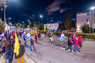 Hayfa, İsrail - 01 Mart 2025: Çeşitli tabelaları ve bayrakları olan insanlar, savaşın sona ermesi, rehine anlaşmasının tamamlanması ve yeni seçimlerin başlatılması için düzenlenen protesto mitingine katıldılar. Hayfa, İsrail