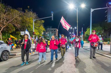 Hayfa, İsrail - 01 Mart 2025: İnsanlar savaşın sona ermesi, rehine anlaşmasının tamamlanması ve yeni seçimler çağrısında bulunan bir protesto yürüyüşüne katılıyor. Hayfa, İsrail