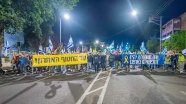 Hayfa, İsrail - 01 Mart 2025: Çeşitli tabelaları ve bayrakları olan insanlar, savaşın sona ermesi, rehine anlaşmasının tamamlanması ve yeni seçimlerin başlatılması için düzenlenen protesto mitingine katıldılar. Hayfa, İsrail