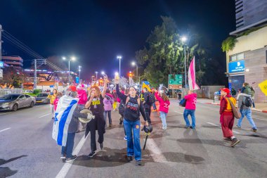 Hayfa, İsrail - 01 Mart 2025: Çeşitli tabelaları ve bayrakları olan insanlar, savaşın sona ermesi, rehine anlaşmasının tamamlanması ve yeni seçimlerin başlatılması için düzenlenen protesto mitingine katıldılar. Hayfa, İsrail