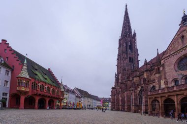 Freiburg, Almanya - 16 Ekim 2024: Minster (katedral) meydanı günbatımı manzarası, yerli halk ve ziyaretçiler, Freiburg im Breisgau, Baden-Wurttemberg, Güneybatı Almanya