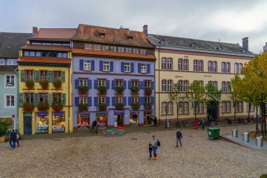 Freiburg, Almanya - 16 Ekim 2024: Freiburg im Breisgau, Baden-Wurttemberg, Güneybatı Almanya 'da çeşitli binalar, yerliler ve ziyaretçilerin bulunduğu Augustinerplatz Meydanı