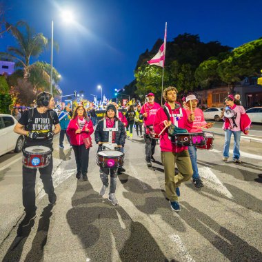 Hayfa, İsrail - 08 Mart 2025: İnsanlar savaşın sona ermesi, rehine anlaşmasının tamamlanması ve yeni seçimler çağrısında bulunan bir protesto yürüyüşüne katılıyor. Hayfa, İsrail