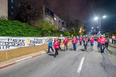 Hayfa, İsrail - 08 Mart 2025: İnsanlar savaşın sona ermesi, rehine anlaşmasının tamamlanması ve yeni seçimler çağrısında bulunan bir protesto yürüyüşüne katılıyor. Hayfa, İsrail