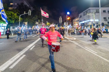 Hayfa, İsrail - 08 Mart 2025: İnsanlar savaşın sona ermesi, rehine anlaşmasının tamamlanması ve yeni seçimler çağrısında bulunan bir protesto yürüyüşüne katılıyor. Hayfa, İsrail