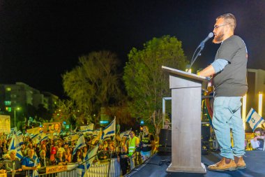 Hayfa, İsrail - 15 Mart 2025: Gal Goren, savaşın sona ermesi, rehine anlaşmasının tamamlanması ve yeni seçimler için düzenlenen protesto mitinginin bir parçası olarak kalabalığa sesleniyor. Hayfa, İsrail