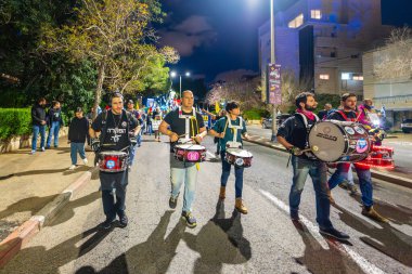 Hayfa, İsrail - 22 Mart 2025: İnsanlar çeşitli işaret ve bayraklarla bir protesto yürüyüşüne katılıyor, savaşın sona ermesi ve rehine anlaşmasının tamamlanması çağrısında bulunuyorlar. Hayfa, İsrail