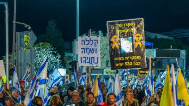 Hayfa, İsrail - 22 Mart 2025: İnsanlar çeşitli işaret ve bayraklarla bir protesto yürüyüşüne katılıyor, savaşın sona ermesi ve rehine anlaşmasının tamamlanması çağrısında bulunuyorlar. Hayfa, İsrail