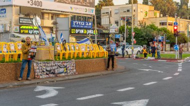 Hayfa, İsrail - 23 Mart 2025: Tabela ve bayraklı insanların günlük protesto gösterileri, rehineleri desteklemek ve anlaşmanın Hayfa, İsrail 'de tamamlanması yönünde çağrıda bulunmaları