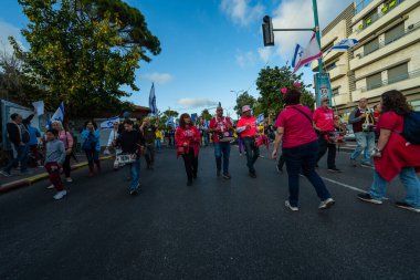 Hayfa, İsrail - 29 Mart 2025: İnsanlar savaşın sona ermesi, rehine anlaşmasının tamamlanması ve yeni seçimler çağrısında bulunan bir protesto yürüyüşüne (Pembe Cephe Grubu) katılıyor. Hayfa, İsrail