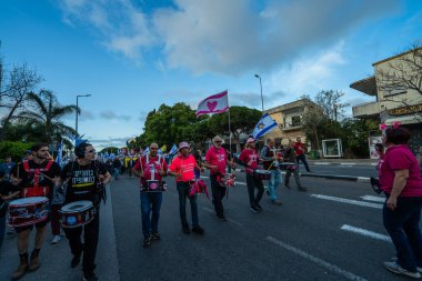 Hayfa, İsrail - 29 Mart 2025: İnsanlar savaşın sona ermesi, rehine anlaşmasının tamamlanması ve yeni seçimler çağrısında bulunan bir protesto yürüyüşüne (Pembe Cephe Grubu) katılıyor. Hayfa, İsrail