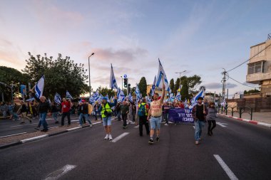 Hayfa, İsrail - 29 Mart 2025: Çeşitli tabelaları ve bayrakları olan insanlar, savaşın sona ermesi, rehine anlaşmasının tamamlanması ve yeni seçimlerin başlatılması için düzenlenen protesto mitingine katıldılar. Hayfa, İsrail
