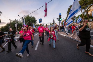 Hayfa, İsrail - 29 Mart 2025: İnsanlar savaşın sona ermesi, rehine anlaşmasının tamamlanması ve yeni seçimler çağrısında bulunan bir protesto yürüyüşüne (Pembe Cephe Grubu) katılıyor. Hayfa, İsrail