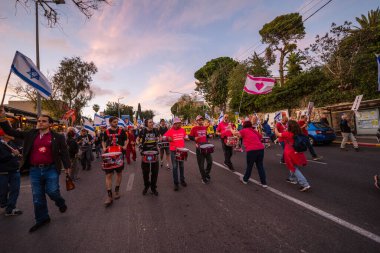 Hayfa, İsrail - 29 Mart 2025: İnsanlar savaşın sona ermesi, rehine anlaşmasının tamamlanması ve yeni seçimler çağrısında bulunan bir protesto yürüyüşüne (Pembe Cephe Grubu) katılıyor. Hayfa, İsrail