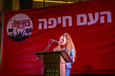 Hayfa, İsrail - 29 Mart 2025: Aktivist Inbal Shoham, savaşın sona ermesi, rehine anlaşmasının tamamlanması ve yeni seçimler için düzenlenen protesto mitinginin bir parçası olarak kalabalığa sesleniyor. Hayfa, İsrail