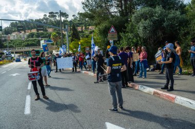 Hayfa, İsrail - 30 Mart 2025: Öğrenciler ve diğerleri, Hamas aileleri tarafından kaçırılan rehinelere destek olmak ve hükümet politikasına karşı gelmek için Technion kapısının dışında duruyorlar. Hayfa, İsrail