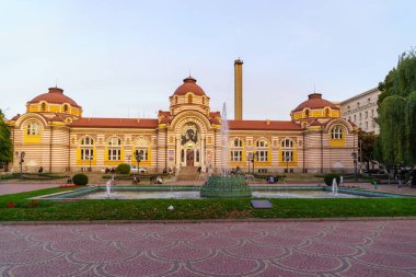 Sofya, Bulgaristan - 09 Ekim 2023: Merkezi Havuz Çeşmesi ve Bulgaristan 'ın Sofya kentinde yerli ve ziyaretçilerle birlikte Bölgesel Tarih Müzesi binasının gün batımı manzarası